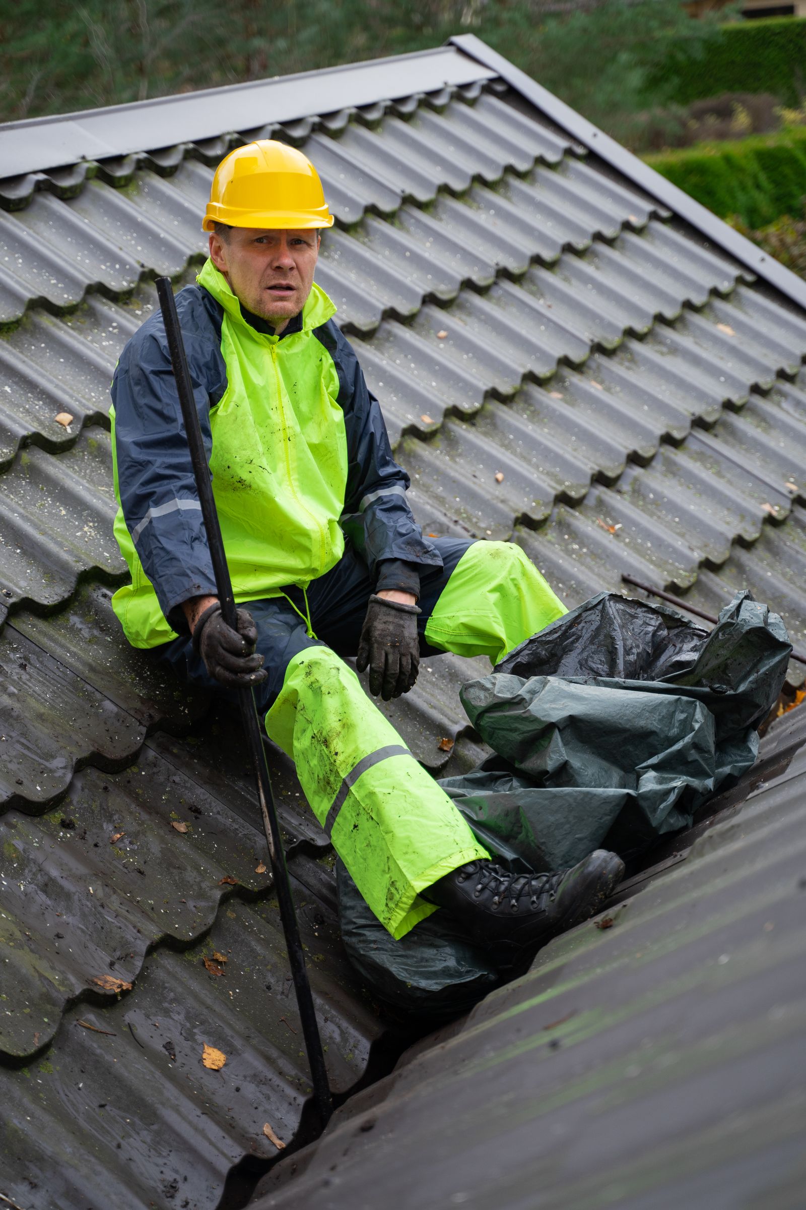 Roofer in safety gear inspecting a roof