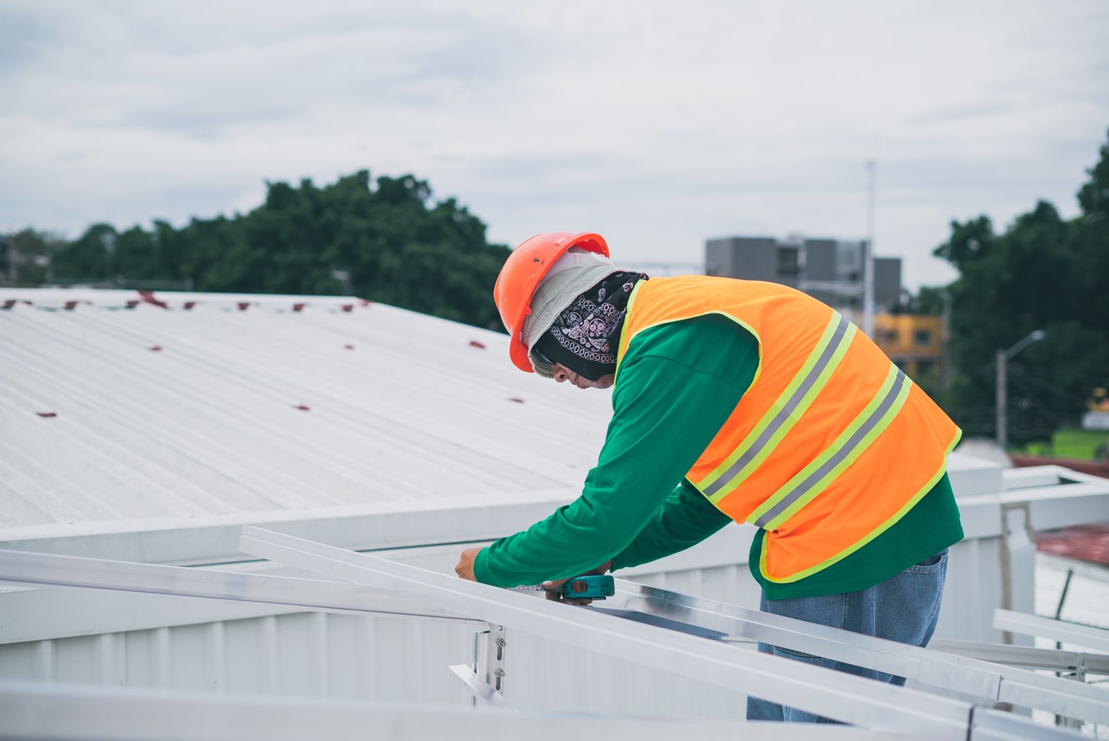 Technician in high-visibility vest carrying out rooftop maintenance