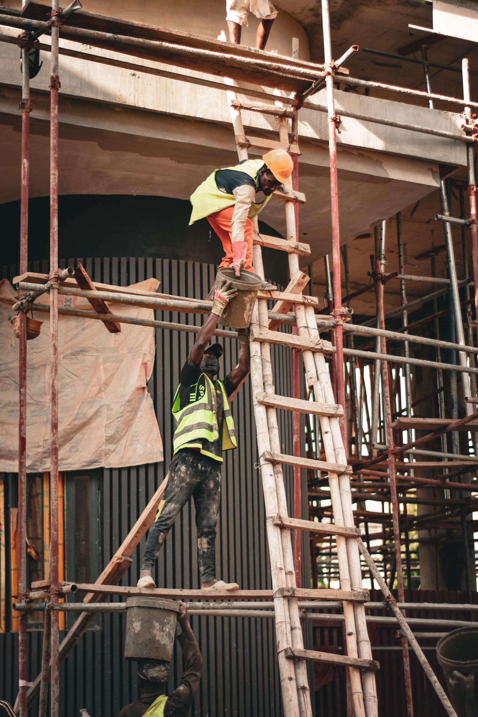 Workers climbing scaffolding on a construction site