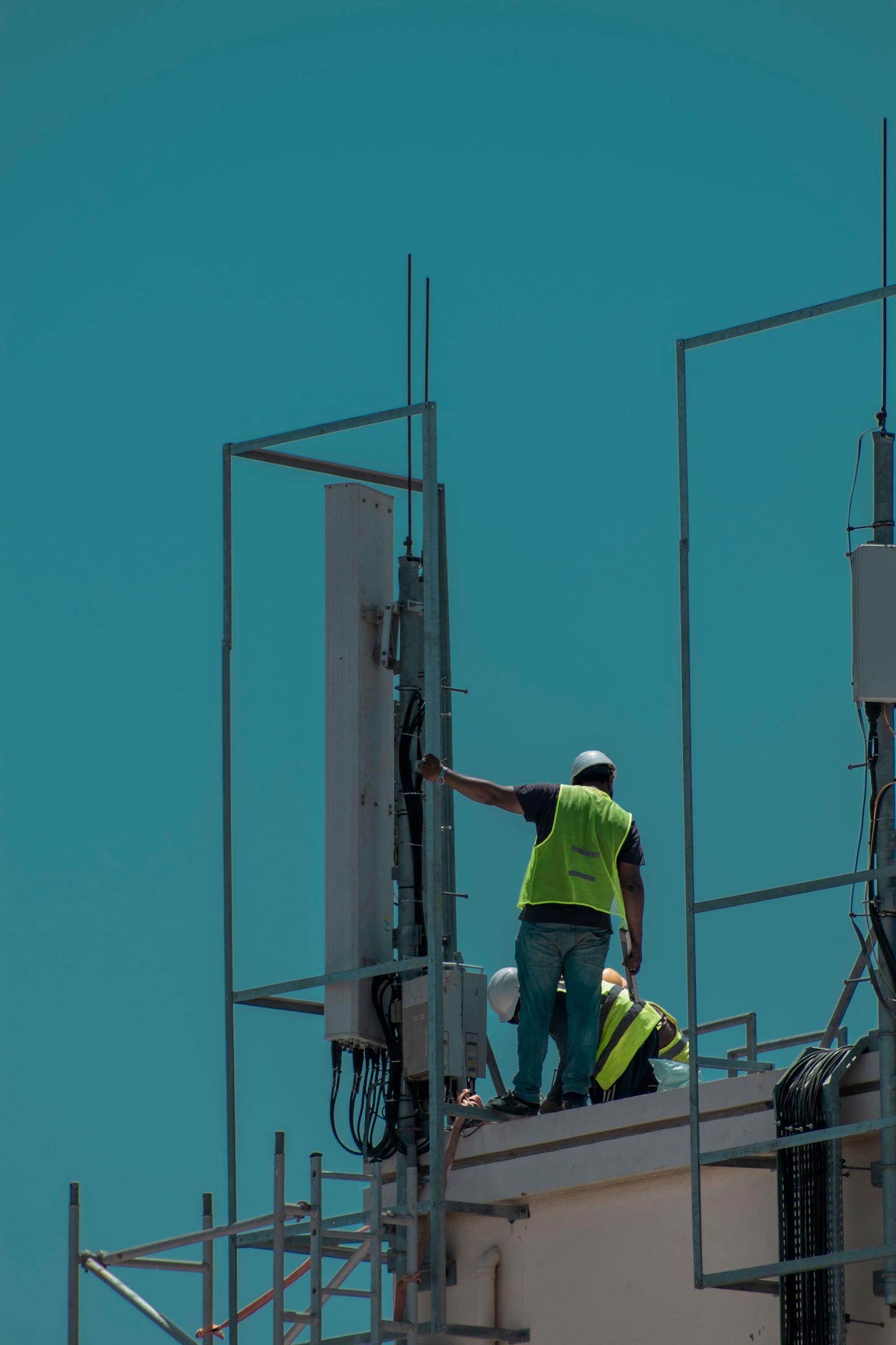 Crew in high-visibility vests and hard hats working on a rooftop installation